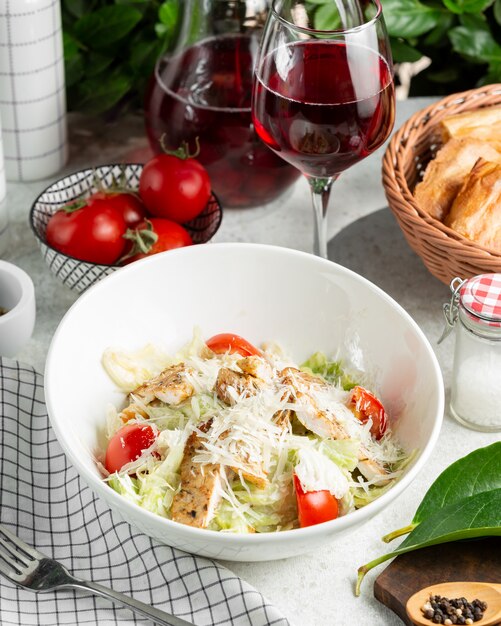 Caesar Salat mit Tomaten, Salat, serviert mit Wein