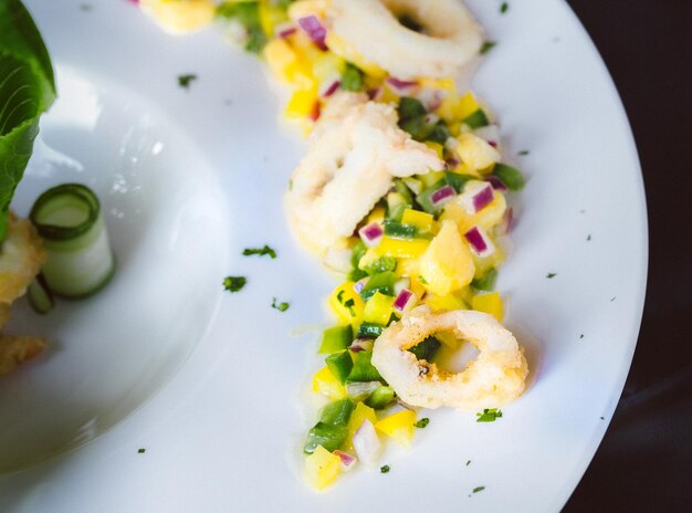 Calamari mit Mangosauce mit schöner Dekoration auf weißem Teller