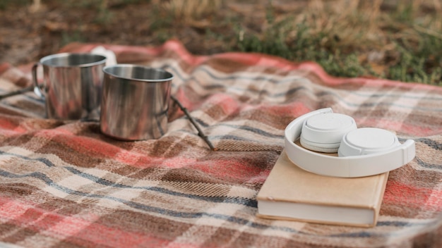 Camping im Freien mit Buch und Bechern für heiße Getränke