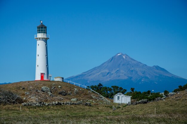 Cape Egmont Lighthouse mit dem Berg Taranaki dahinter in Pungarehu, Neuseeland