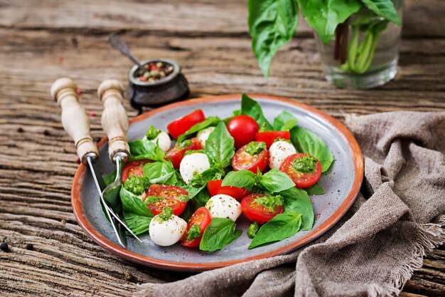 Capresesalat. Gesunde Mahlzeit mit Kirschtomaten, Mozzarellabällchen und Basilikum. Hausgemachtes, leckeres Essen. Konzept für eine schmackhafte und gesunde vegetarische Mahlzeit.