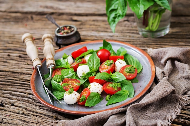 Capresesalat. Gesunde Mahlzeit mit Kirschtomaten, Mozzarellabällchen und Basilikum. Hausgemachtes, leckeres Essen. Konzept für eine schmackhafte und gesunde vegetarische Mahlzeit.