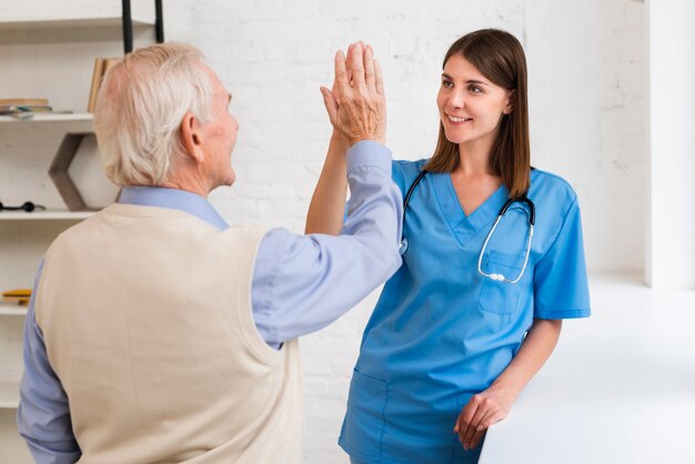 Caregiver High Fiving mit alten Mann