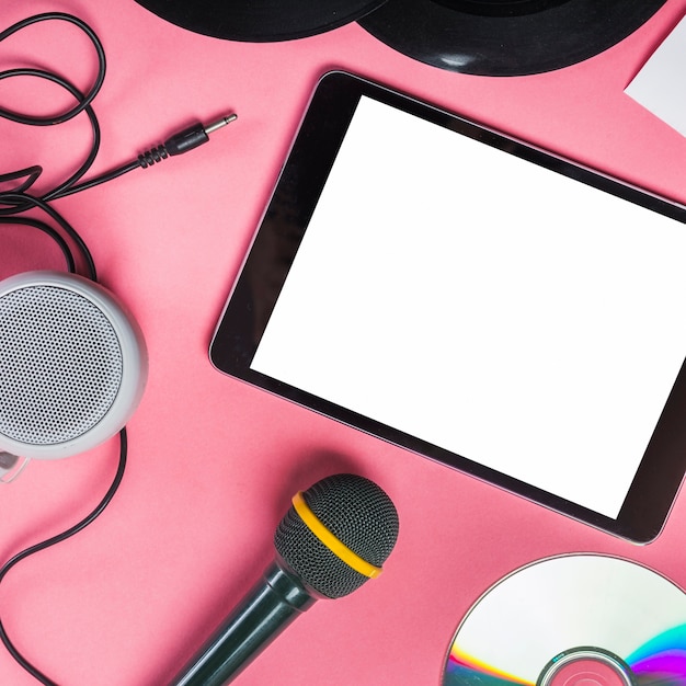 CD; Schallplatte; Mikrofon; Lautsprecher und digitale Tablet auf rosa Hintergrund
