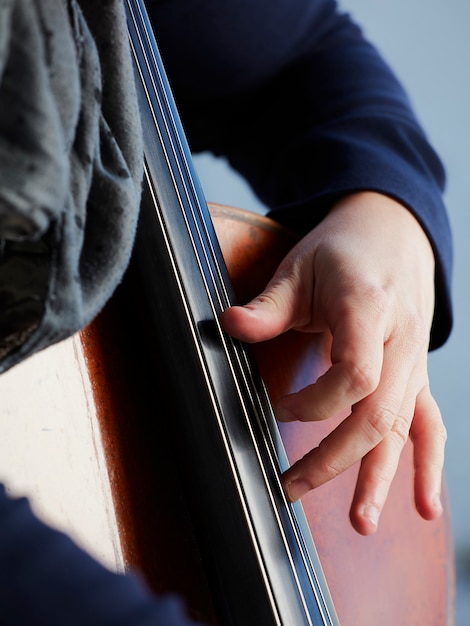 Cellist Spieler Hände. Violoncellist, der Cello auf Hintergrund des Feldes spielt. Musikalische Kunst, Konzept Leidenschaft in der Musik. Professioneller Cellospieler der klassischen Musik solo durchführen