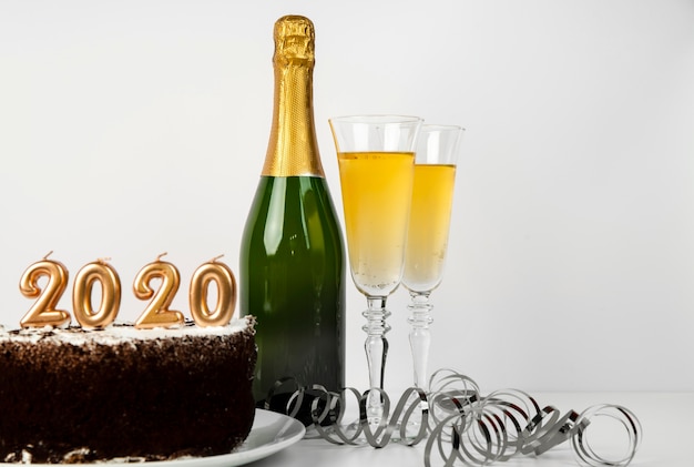 Kostenloses Foto champagner und kuchen mit 2020 ziffern des neuen jahres