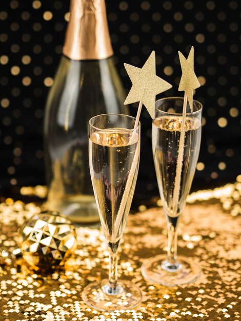 Champagnergläser mit Sternen und goldenem Stoff