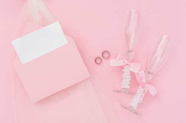 Champagnergläser neben Hochzeitseinladung