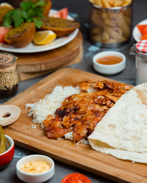 Champignons und Fleisch in Tomatensauce anbraten und mit Reis und Lavash servieren.