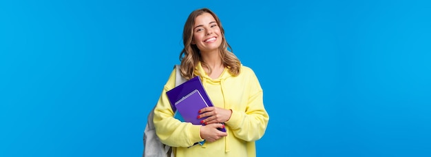 Kostenloses Foto charismatische, fröhliche europäische frauen tragen rucksack und notizbücher, während sie zum nächsten vortrag gehen und glücklich lächeln