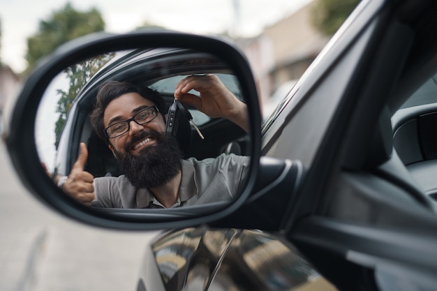 Kostenloses Foto charismatischer mann, der autoschlüssel hält