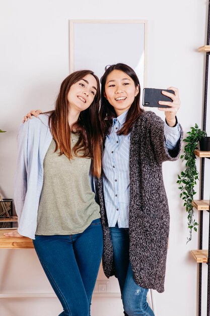 Charmante junge Freundinnen, die selfie nehmen