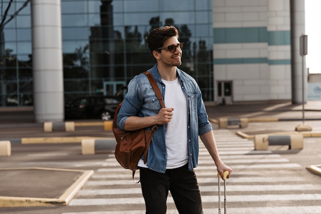 Charmanter Mann mit Sonnenbrille lächelt aufrichtig