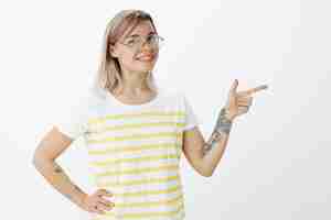 Kostenloses Foto charmantes blondes mädchen mit brille, die im studio aufwirft
