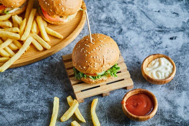 Cheeseburger mit Bratkartoffel auf dem Holzbrett