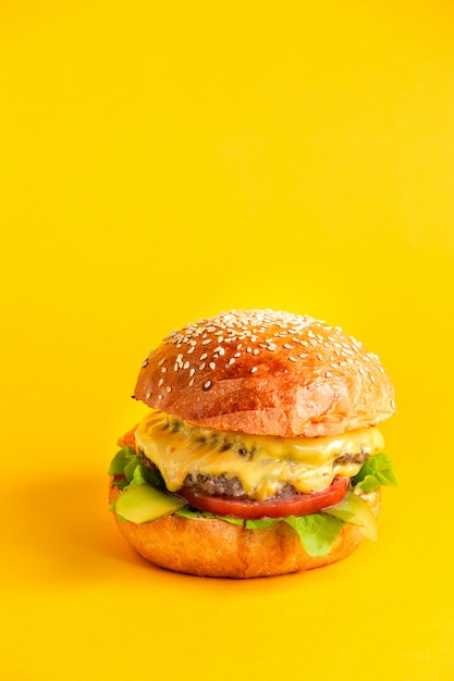 Cheeseburger mit doppelter Rindfleischpastetchen und Käsetomaten-Salatblattsauce und eingelegter Gurke in Burgerbrötchen