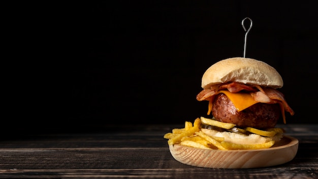 Cheeseburger und Pommes Frites von vorne auf Holztablett mit Ablagefläche