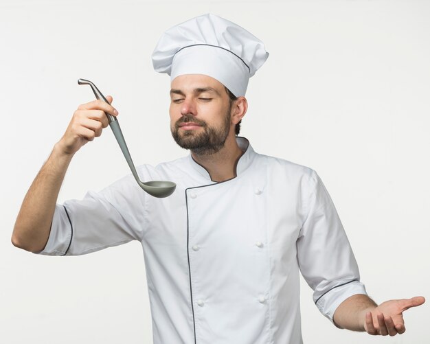 Chef, der den Geruch der Suppe in der Schöpfkelle genießt