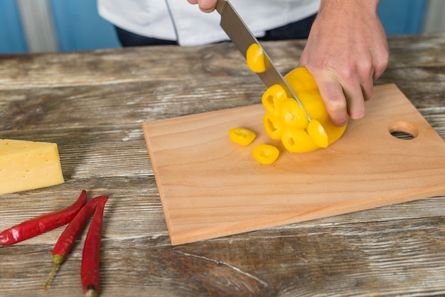 Chef, der gelben Pfeffer schneidet