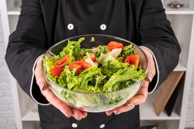 Chef, der Schüssel Salat hält