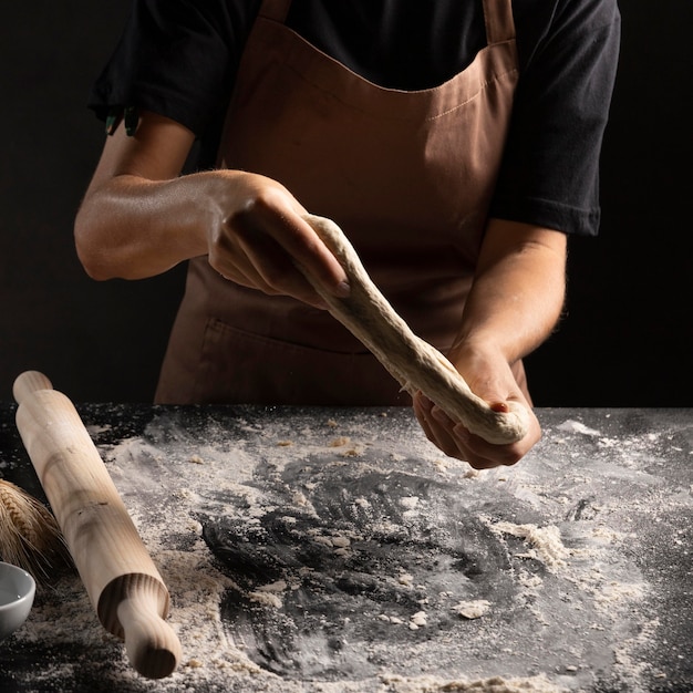 Chef, der Teig mit den Händen streckt