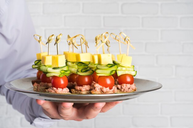 Chef, der Teller mit Catering-Essen hält