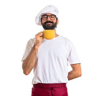 Chef hält eine tasse kaffee