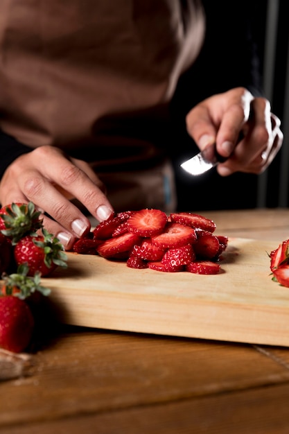 Chef mit Schürze, die Erdbeeren hackt