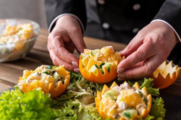 Kostenloses Foto chefkoch arrangiert gericht mit salat und orangen
