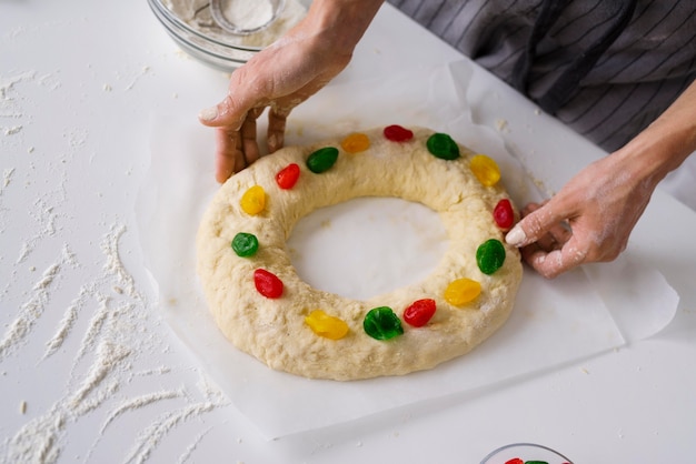 Chefkoch, der Dreikönigstagsdessert mit bunten Süßigkeiten vorbereitet