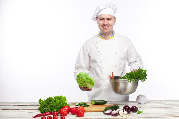 Chefkoch, der frischen Gemüsesalat in seiner Küche kocht