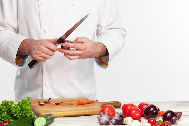 Chefkoch, der frischen Gemüsesalat in seiner Küche kocht