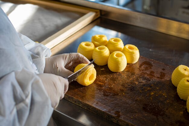 Chefkoch, der gelbe Äpfel auf dem Brett schneidet