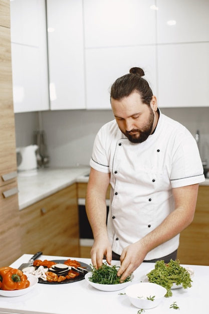 Chefkoch, der in der Küche zu Hause steht und kocht