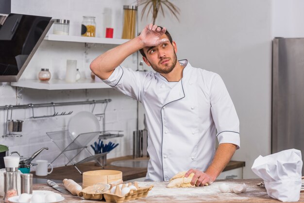 Kostenloses Foto chefkoch in der küche, die teig macht