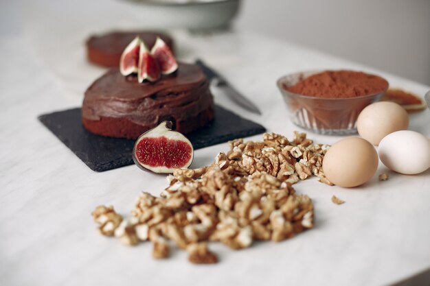 Chefkoch in weißer Kleidung bereitet einen Schokoladenkuchen zu. Dame bereitet Dessert vor. Frau backt einen Kuchen.