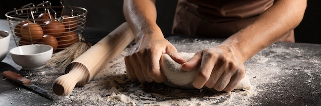 Chefkoch mit den Händen und Mehl, um den Teig zu kneten