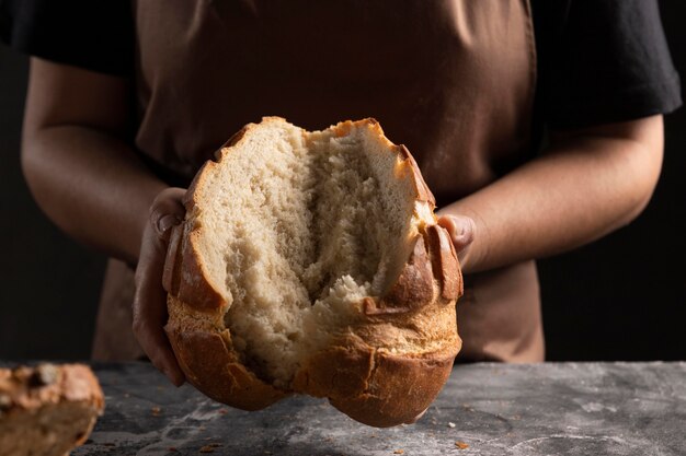 Chefkoch zerreißt frisch gebackenes Brot auseinander