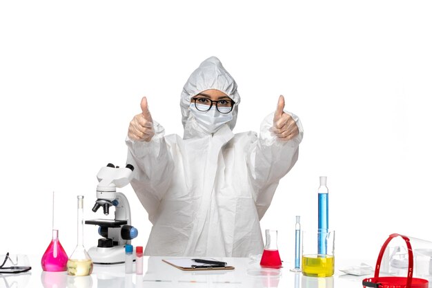 Chemikerin der Vorderansicht im speziellen Schutzanzug lächelnd auf weißem Hintergrund covid-Chemie-Viruslabor