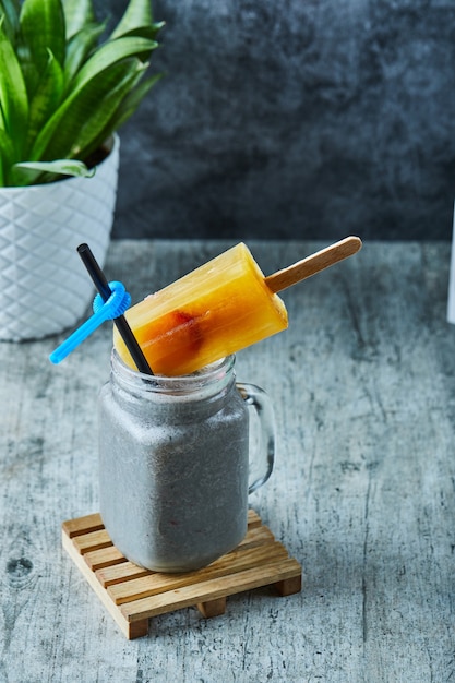 Chia-Milchshake mit Eis und Stroh auf der Marmoroberfläche