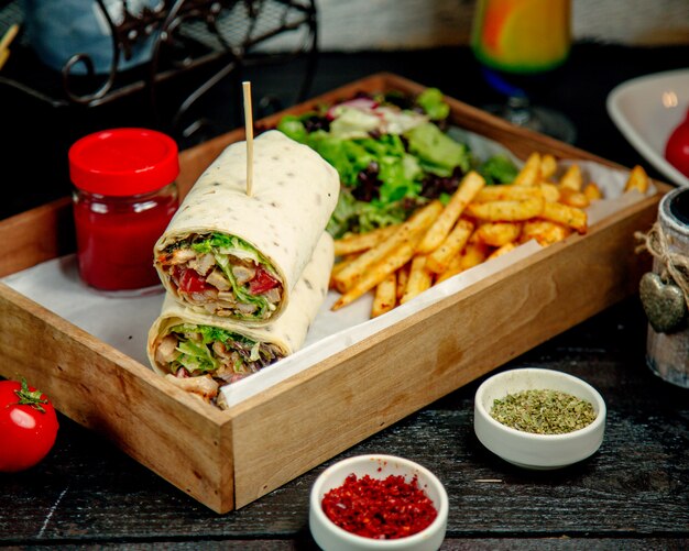 Chicken Wrap serviert mit Pommes Frites Salat Salat und Sauce