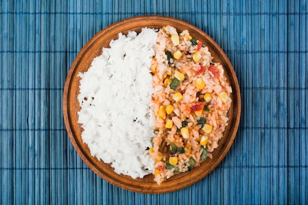 Chinese briet und dämpfte Reis auf hölzerner Platte über dem blauen placemat