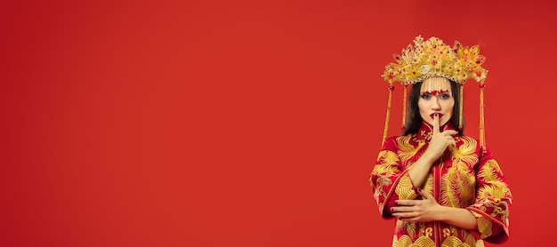 Kostenloses Foto chinesische traditionelle anmutige frau im studio über rot.