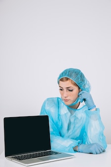 Chirurg posiert mit laptop-bildschirm