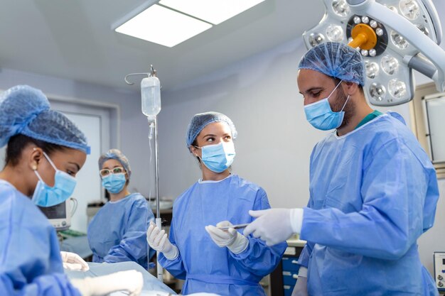 Chirurgisches Team, das Operationen in einem modernen Operationssaal durchführtTeam von Ärzten, die sich während einer Operation auf einen Patienten konzentrierenTeam von Ärzten, die während einer Operation im Operationssaal zusammenarbeiten