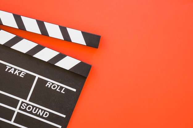 Clapperboard auf rotem Hintergrund mit Platz