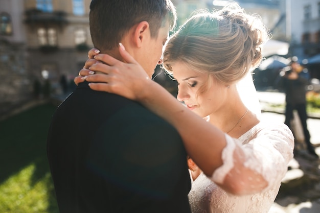 Close-up der Braut mit den Händen um den Hals des Bräutigams