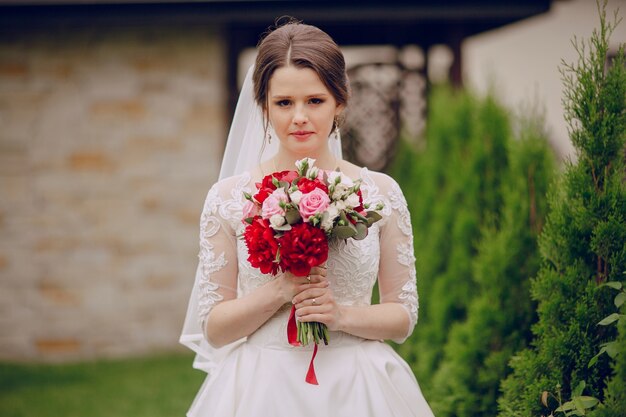 Close-up der Braut mit ihrem Blumenstrauß im Freien