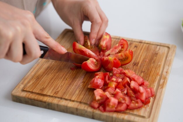 Close-up der Frau schneiden Tomaten mit Messer