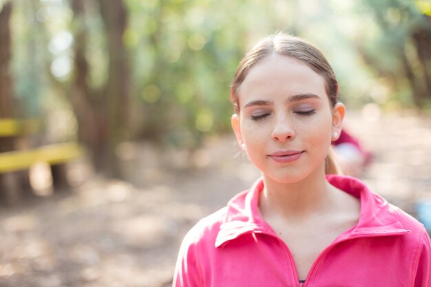 Close-up der jungen Frau mit rosa Sweatshirt im Freien genießen